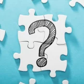Elevated View Of Question Mark Icon On White Puzzle Over The Blue Background